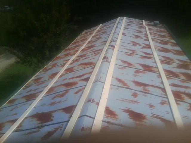Rusted metal roof panels with new wood purlins before replacement — Storm Damage Roof Repair in East Prospect by Roofing Brothers