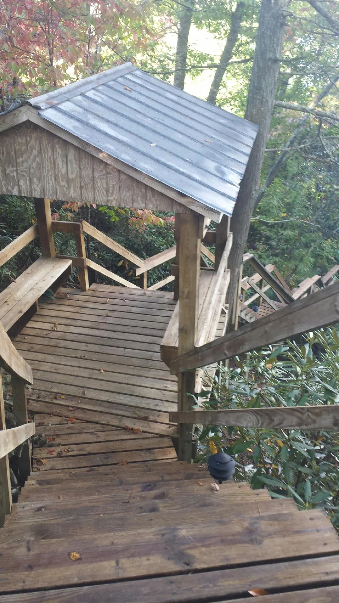Metal roofed shelter over wooden steps on a wooded walkway — Skylight Repair & Installation work by our crew in East Prospect